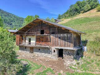 Discover this rustic wooden barn nestled in a serene mountain landscape, perfect for renovation or development.
