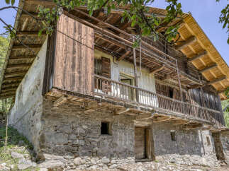 Discover this charming rustic property featuring a stone base and weathered wooden upper floors, offering a unique blend of traditional architecture and natural beauty.