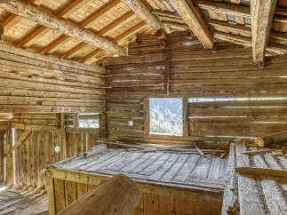 Step into a rustic dream with this charming log cabin interior, featuring exposed wooden beams and walls that exude warmth and character.