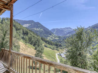 Experience breathtaking mountain views from this charming property's wooden balcony, perfect for enjoying your morning coffee or evening relaxation.