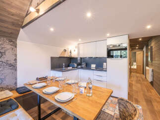 This charming kitchen and dining area features a modern L-shaped countertop with integrated appliances, perfect for meal preparation.