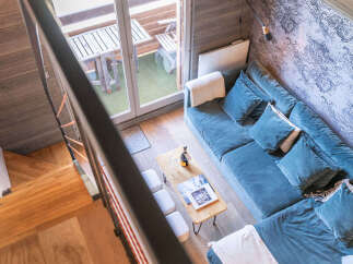 Experience modern living in this stylish apartment featuring a plush blue sectional sofa and a chic coffee table.
