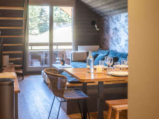 This inviting living space features a cozy dining area with a wooden table and chairs, perfect for family meals.