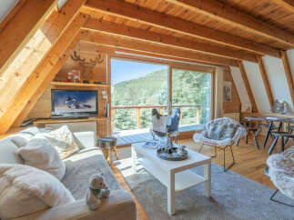 Experience breathtaking mountain views from this charming A-frame chalet living room.