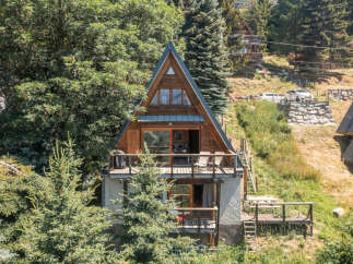 Discover this charming A-frame cabin nestled amidst lush greenery, offering a unique architectural style and stunning natural surroundings.