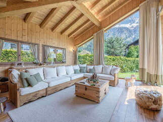 Experience rustic charm and breathtaking mountain views in this cozy wooden living room.