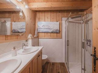 Experience rustic charm in this beautifully appointed bathroom featuring a double vanity with modern fixtures and a spacious walk-in shower.