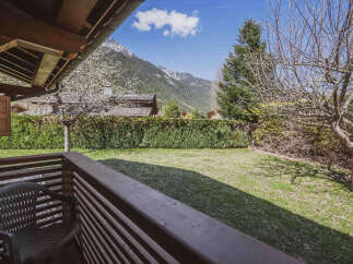 Enjoy the serene mountain views from this charming property, featuring a lush green lawn perfect for outdoor activities.