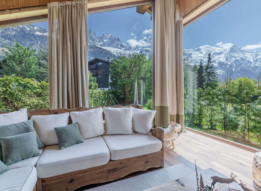 Experience breathtaking mountain views from this stunning living space, featuring a comfortable sectional sofa perfect for relaxing.