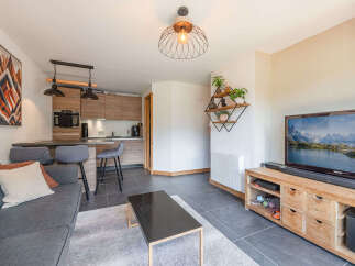 Discover this modern living space featuring a sleek kitchen with ample cabinet storage and a breakfast bar perfect for casual dining.