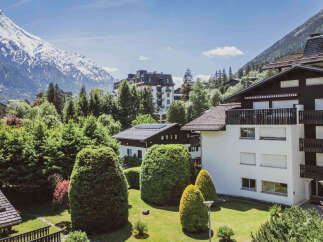 Experience breathtaking mountain views from this stunning property, nestled amidst lush greenery and towering trees.