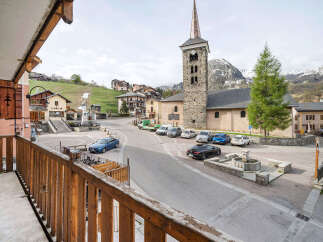 Experience the charm of alpine living in this picturesque village setting, complete with a historic church and stunning mountain backdrop.