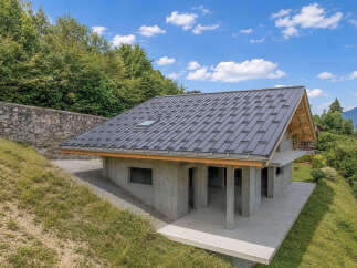 Discover this modern concrete home nestled on a hillside, offering stunning natural views.