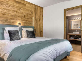 Experience rustic charm in this inviting bedroom featuring a cozy bed with plush pillows and a soothing teal throw.