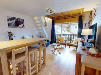 Experience cozy mountain living in this charming apartment, featuring a rustic wooden bar with stools perfect for casual dining or entertaining.