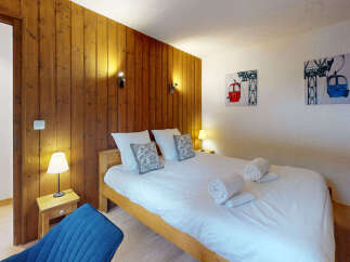Experience cozy mountain living in this charming bedroom featuring a warm wooden accent wall and a comfortable queen-sized bed.