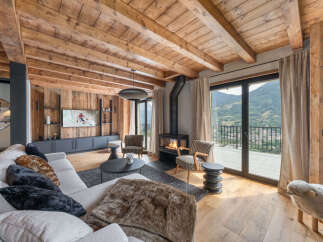 Experience luxurious mountain living in this stunning chalet-style living room, featuring a cozy fireplace and breathtaking panoramic views.