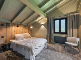 Experience cozy mountain living in this charming bedroom featuring a plush bed adorned with a luxurious faux fur throw.