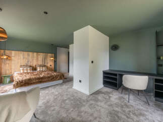 Experience ultimate comfort in this luxurious bedroom featuring a plush, fur-covered bed with a rustic wooden headboard.