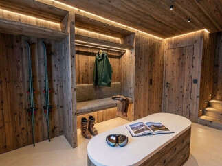 Experience rustic luxury in this mountain retreat, featuring a cozy entryway with ample storage for ski gear and a comfortable bench.