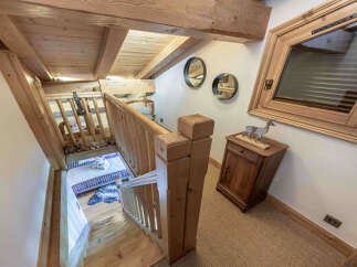 Ascend to a charming loft space featuring exposed wooden beams and a cozy sleeping nook.