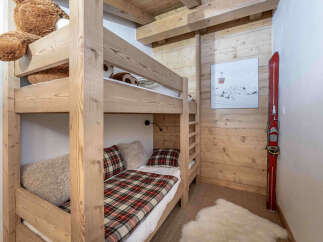 Experience cozy mountain living in this charming bedroom featuring a sturdy wooden bunk bed, perfect for families or guests.