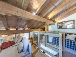Experience cozy living in this charming loft space, featuring exposed wooden beams and a sloped ceiling that adds rustic character.