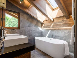 Experience luxury in this stunning bathroom featuring a freestanding bathtub and modern vessel sinks.
