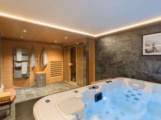 Indulge in ultimate relaxation in this luxurious spa area, featuring a spacious hot tub with soothing blue lighting and a modern sauna.