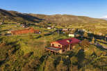 Discover this stunning mountain retreat featuring a spacious log home with a durable red metal roof and a large deck perfect for enjoying the breathtaking panoramic views.
