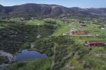 Discover this stunning property nestled in a picturesque mountain landscape, featuring a charming pond and expansive green fields.