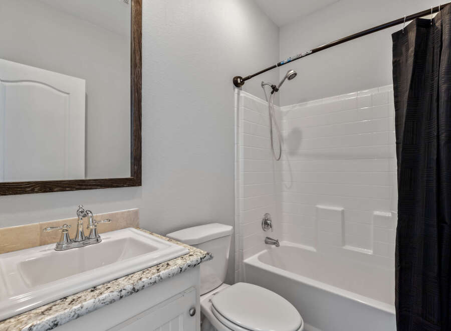 This bathroom features a white sink with a chrome faucet, set against a granite countertop.
