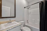 This bathroom features a white sink with a chrome faucet, set against a granite countertop.