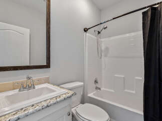 This bathroom features a white sink with a chrome faucet, set against a granite countertop.