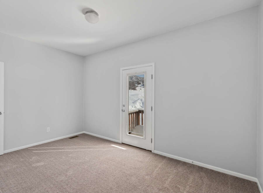 Step outside to a winter wonderland from this inviting room, featuring a glass door that opens to a snow-covered deck and scenic views.
