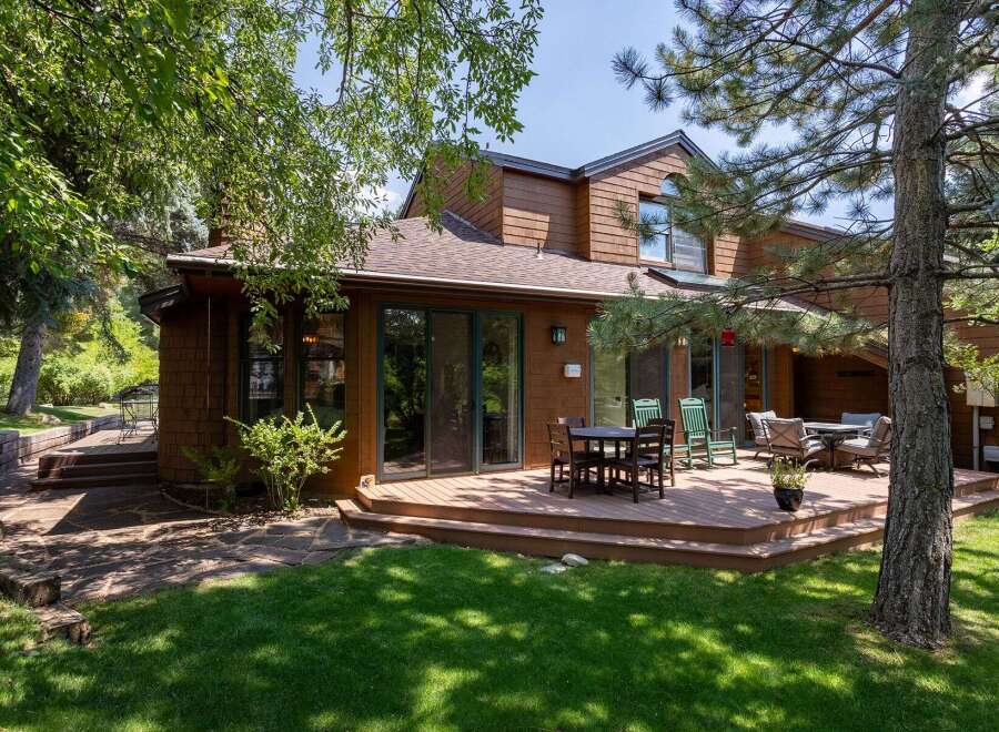 Enjoy outdoor living on this expansive wooden deck, perfect for entertaining or relaxing amidst lush greenery.