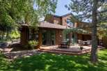 Enjoy outdoor living on this expansive wooden deck, perfect for entertaining or relaxing amidst lush greenery.