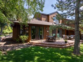 Enjoy outdoor living on this expansive wooden deck, perfect for entertaining or relaxing amidst lush greenery.