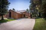 Nestled amidst mature trees, this charming brown wood-sided home offers a serene retreat.