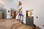 Step into this inviting entryway featuring a beautiful wooden staircase and a cozy built-in bar area perfect for entertaining.