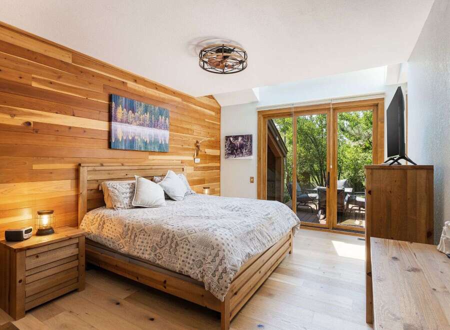 Experience rustic charm in this beautifully appointed bedroom, featuring warm cedar plank walls and a comfortable wooden bed.
