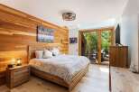 Experience rustic charm in this beautifully appointed bedroom, featuring warm cedar plank walls and a comfortable wooden bed.