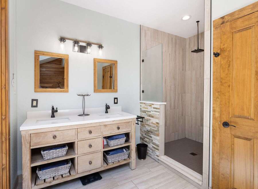 Experience luxury in this modern bathroom featuring a spacious double vanity with ample storage and elegant fixtures.