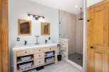 Experience luxury in this modern bathroom featuring a spacious double vanity with ample storage and elegant fixtures.