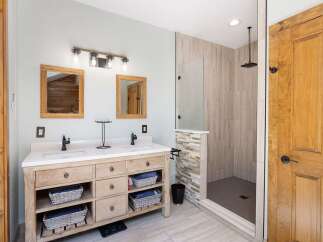 Experience luxury in this modern bathroom featuring a spacious double vanity with ample storage and elegant fixtures.