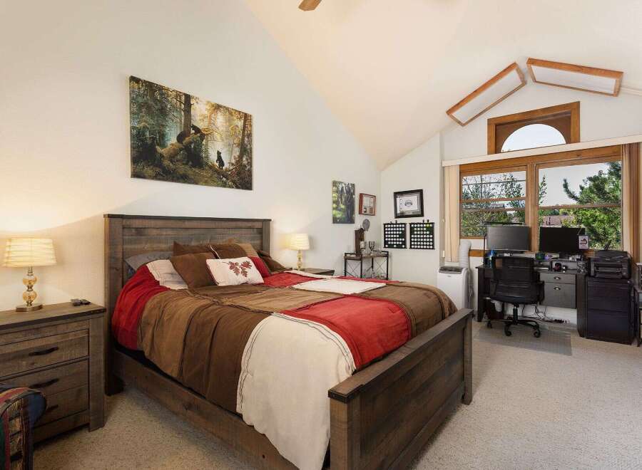 This charming bedroom features a rustic wooden bed with a patchwork quilt, complemented by a matching nightstand and lamp.