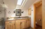 Discover this charming bathroom featuring a spacious vanity with a granite countertop and ample wooden cabinetry.