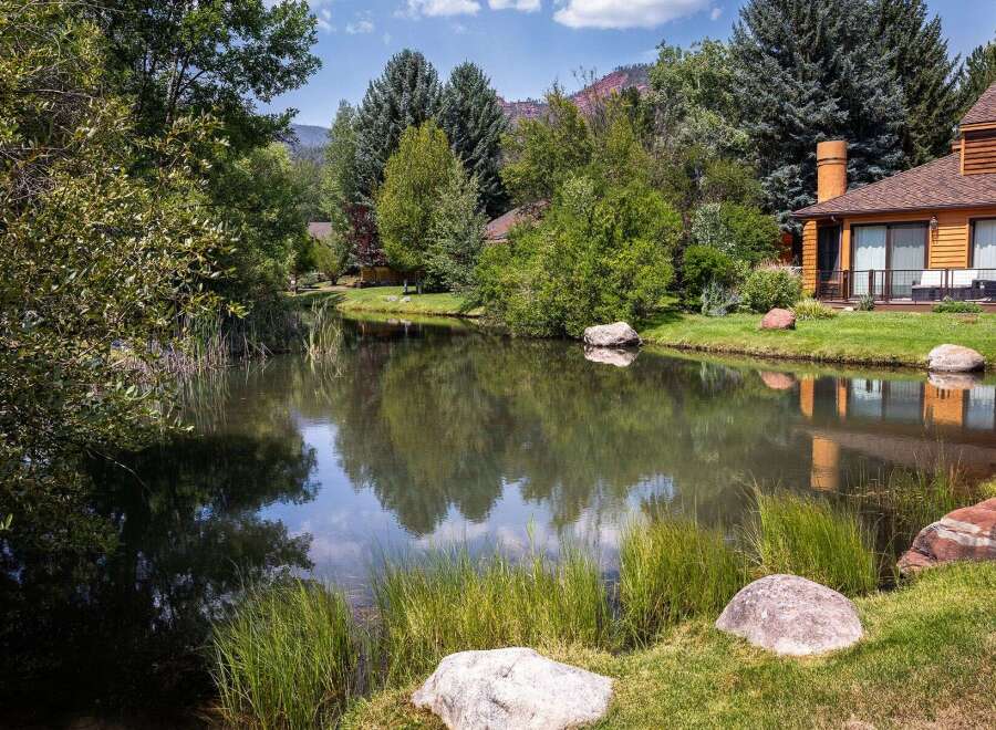 Experience serene living with this stunning property featuring a tranquil pond and lush greenery, perfect for relaxation and outdoor enjoyment.