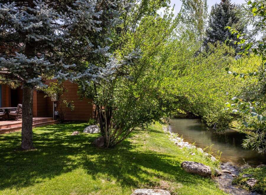Enjoy serene outdoor living with this charming property featuring a spacious deck overlooking a tranquil creek.