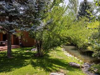 Enjoy serene outdoor living with this charming property featuring a spacious deck overlooking a tranquil creek.